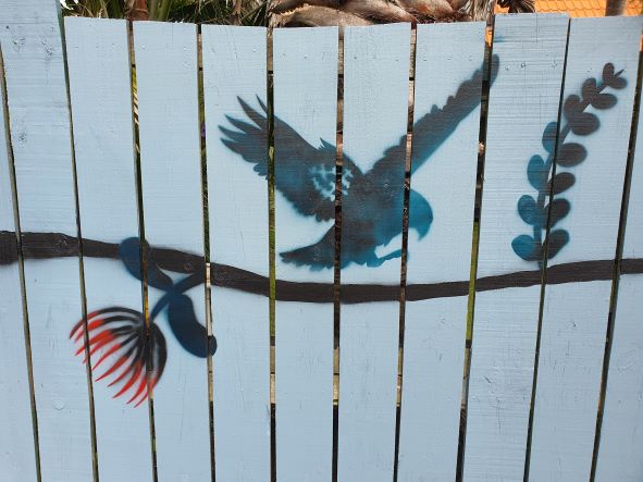 Various New Zealand birds depicted in a fence mural, in silhouette form
